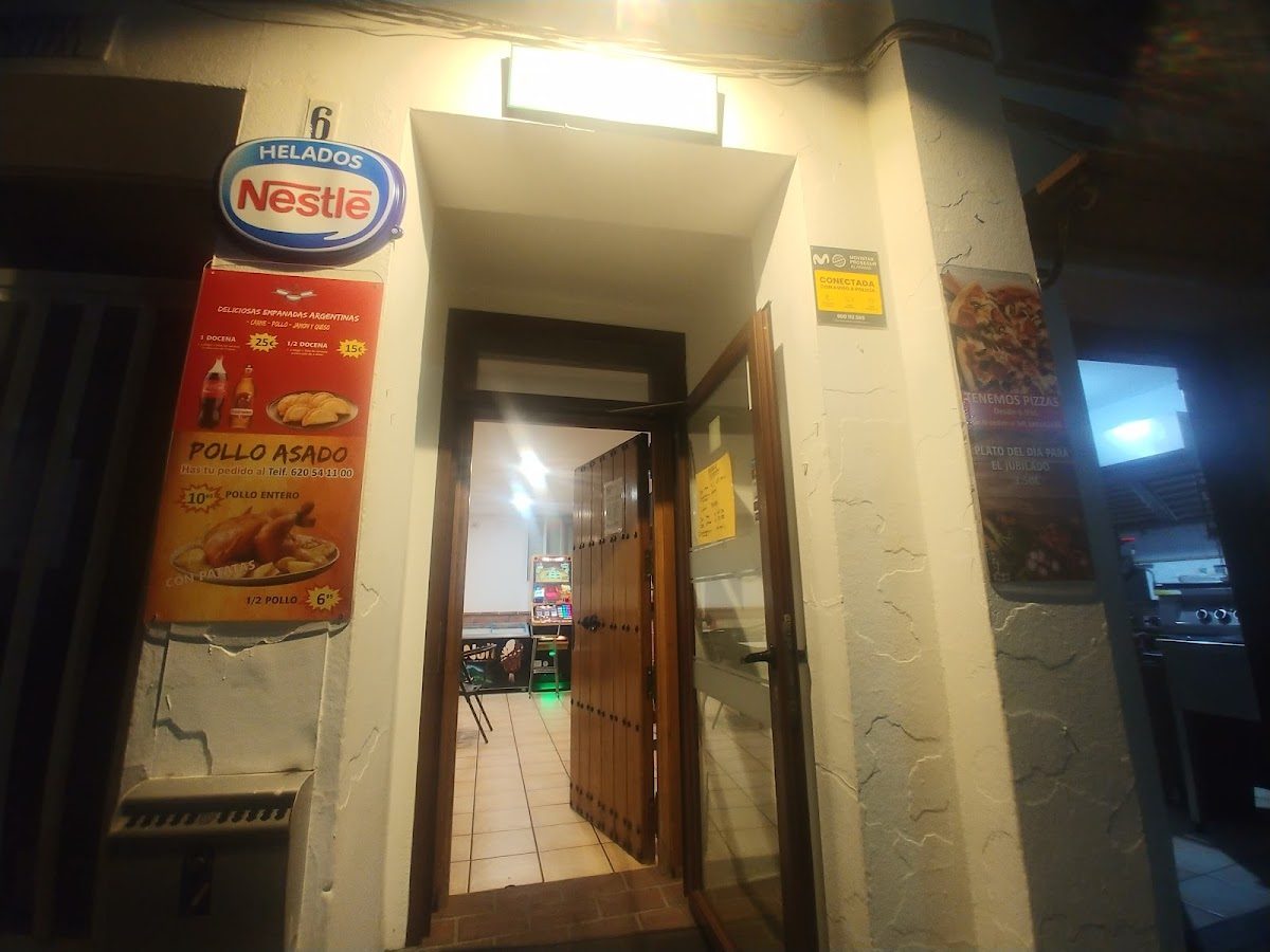 Entrance of Hogar del Jubilado with signage for Nestlé ice cream and a menu featuring pollo asado.