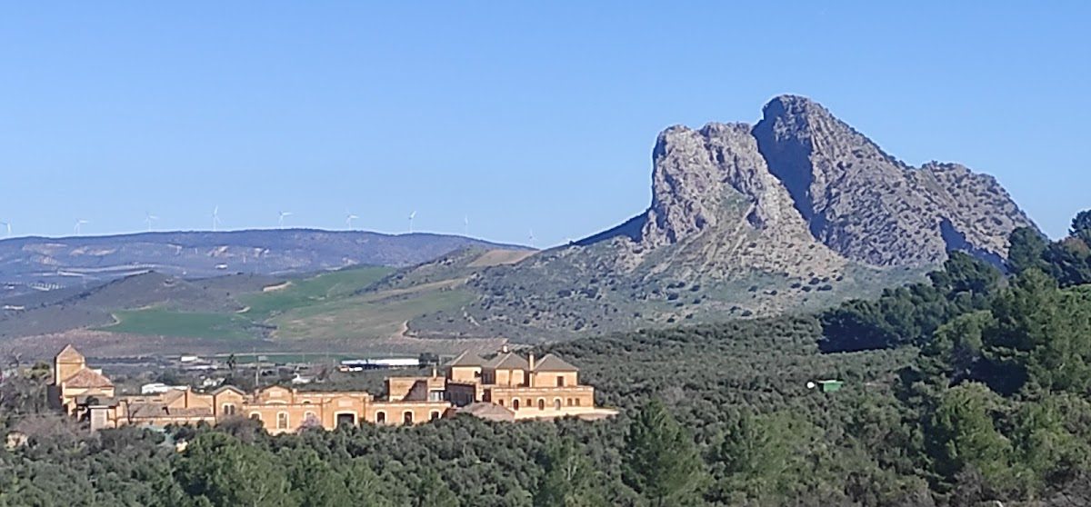 A panoramic view of the Hospital de Antequera Urgencias surrounded by hills and mountains.