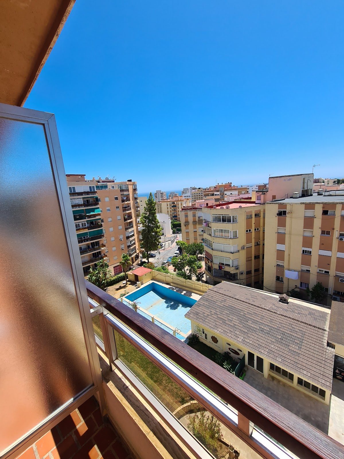 View from Hotel Carlos I balcony showcasing a pool and surrounding buildings under a clear blue sky.