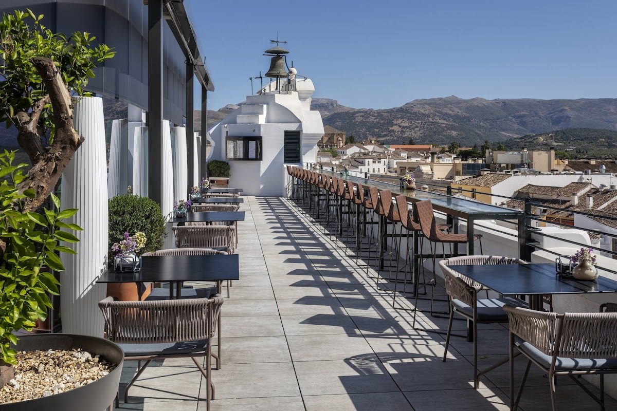 Rooftop terrace with seating and mountain views at Hotel Catalonia Ronda.