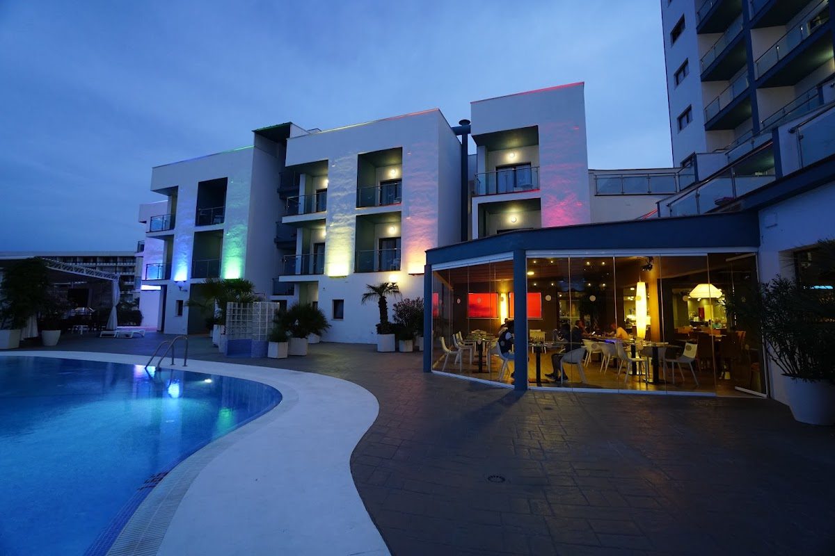 Hotel Ritual Torremolinos features a modern exterior with colorful lighting and a poolside dining area.