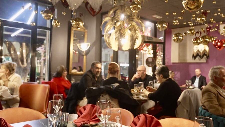 El elegante interior de Indian Flavour, con decoraciones festivas y comensales disfrutando de sus comidas.