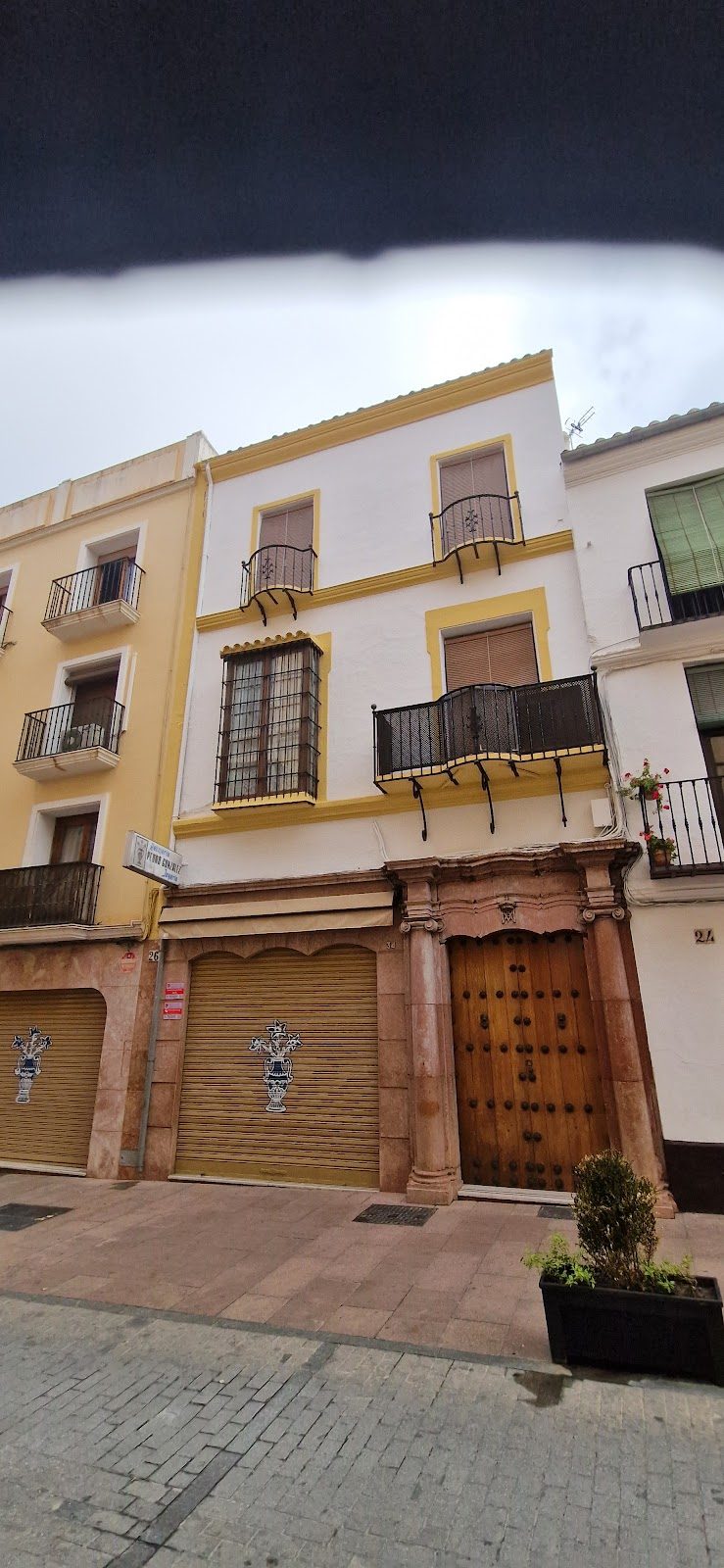 El exterior de Joyería Pedro González presenta una puerta de madera y trabajos decorativos en piedra, con balcones en la parte superior.