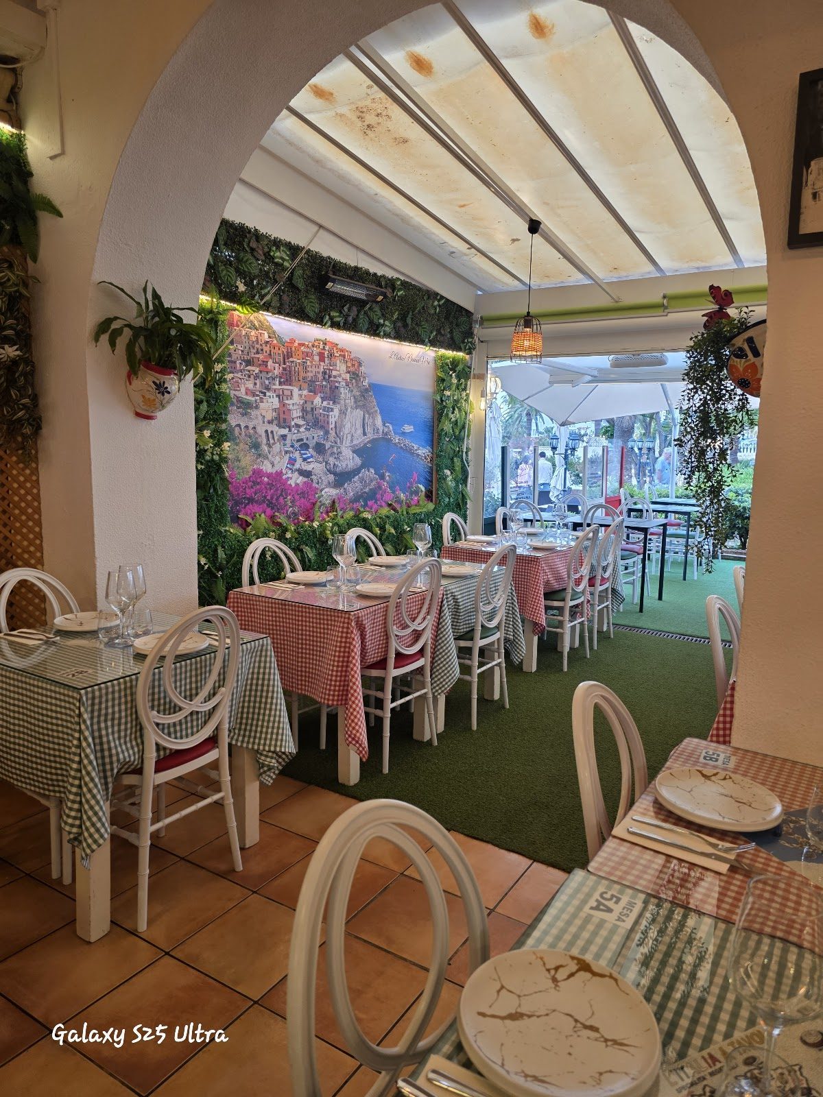 L'antica Nonna Mia features a charming dining area with checkered tablecloths and vibrant wall decor.