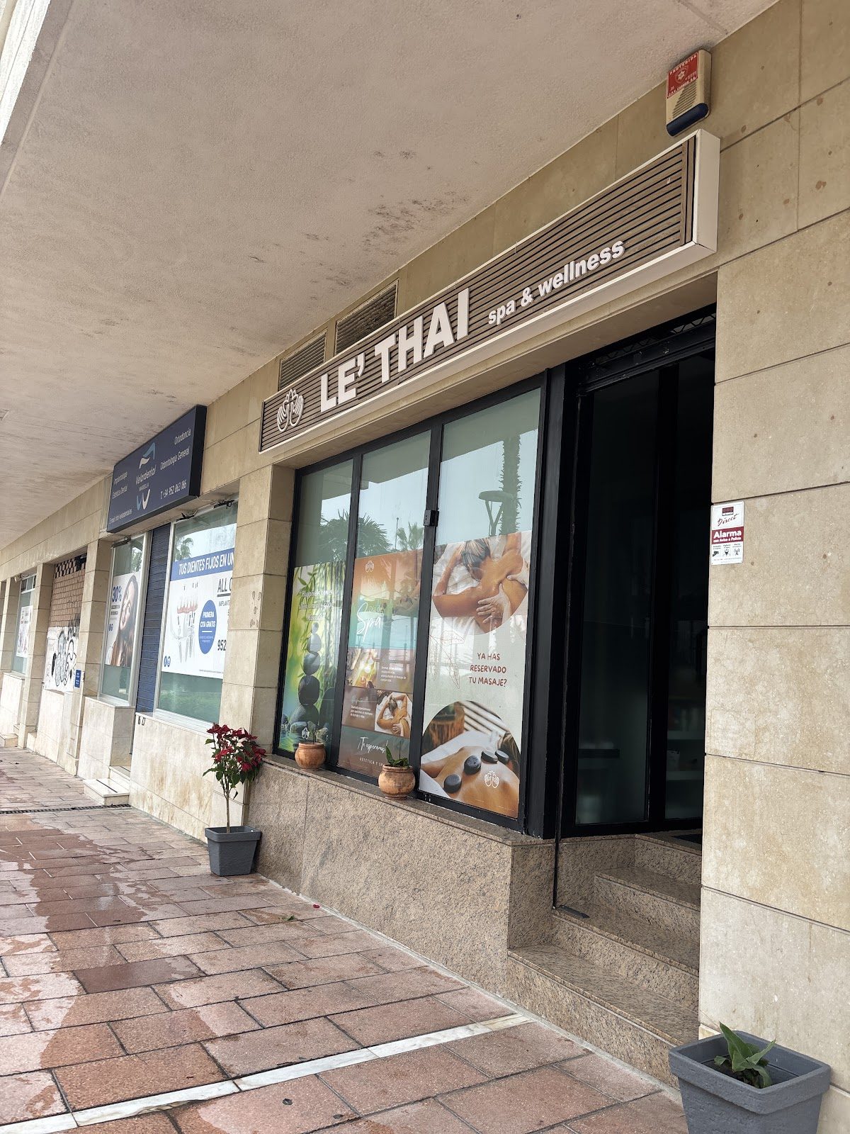 The entrance of LE´THAI Spa & Wellness features large windows and promotional signage.