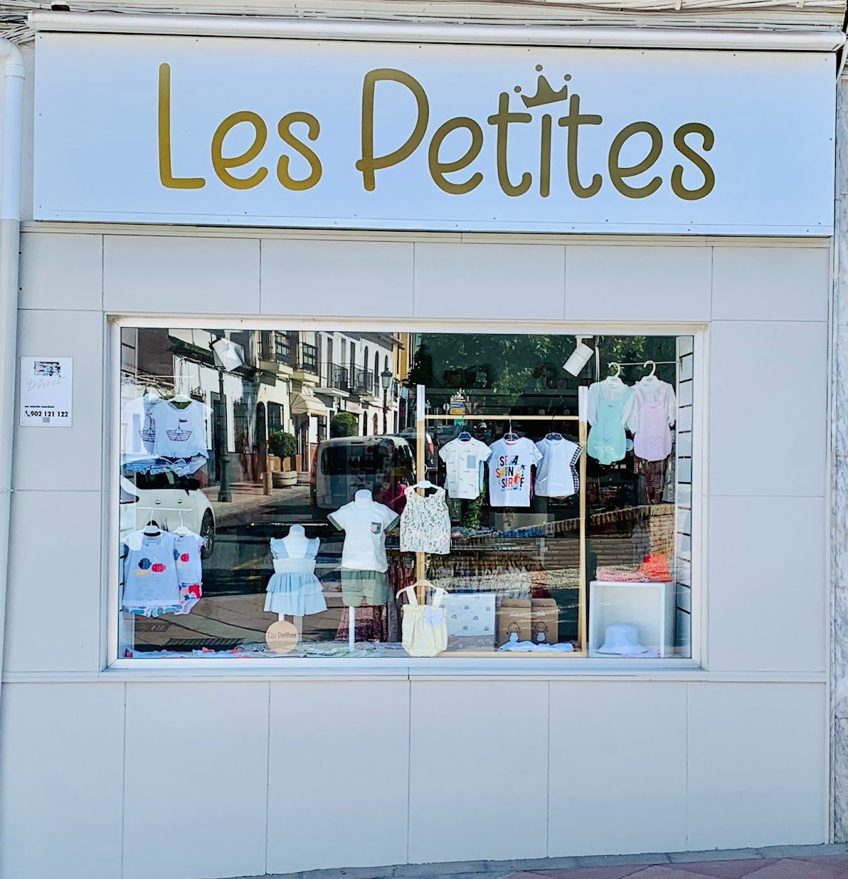 The storefront of Les Petites displays children's clothing in a bright window.