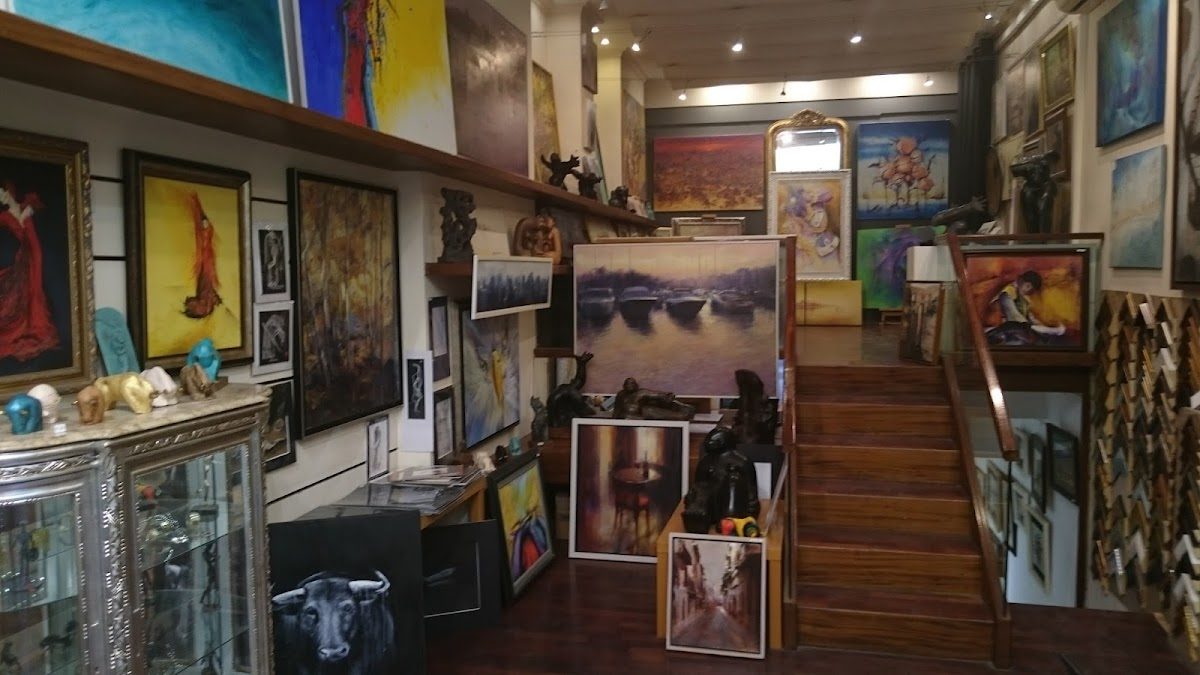 La galería de arte Libertad Couso presenta una variedad de coloridas pinturas y esculturas expuestas en todo el espacio.