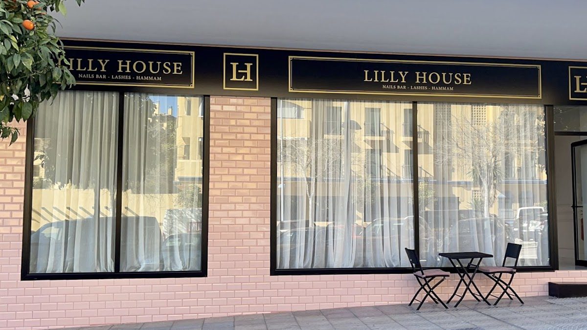 Lilly House presenta un exterior elegante con grandes ventanales y una pequeña zona de estar al aire libre.