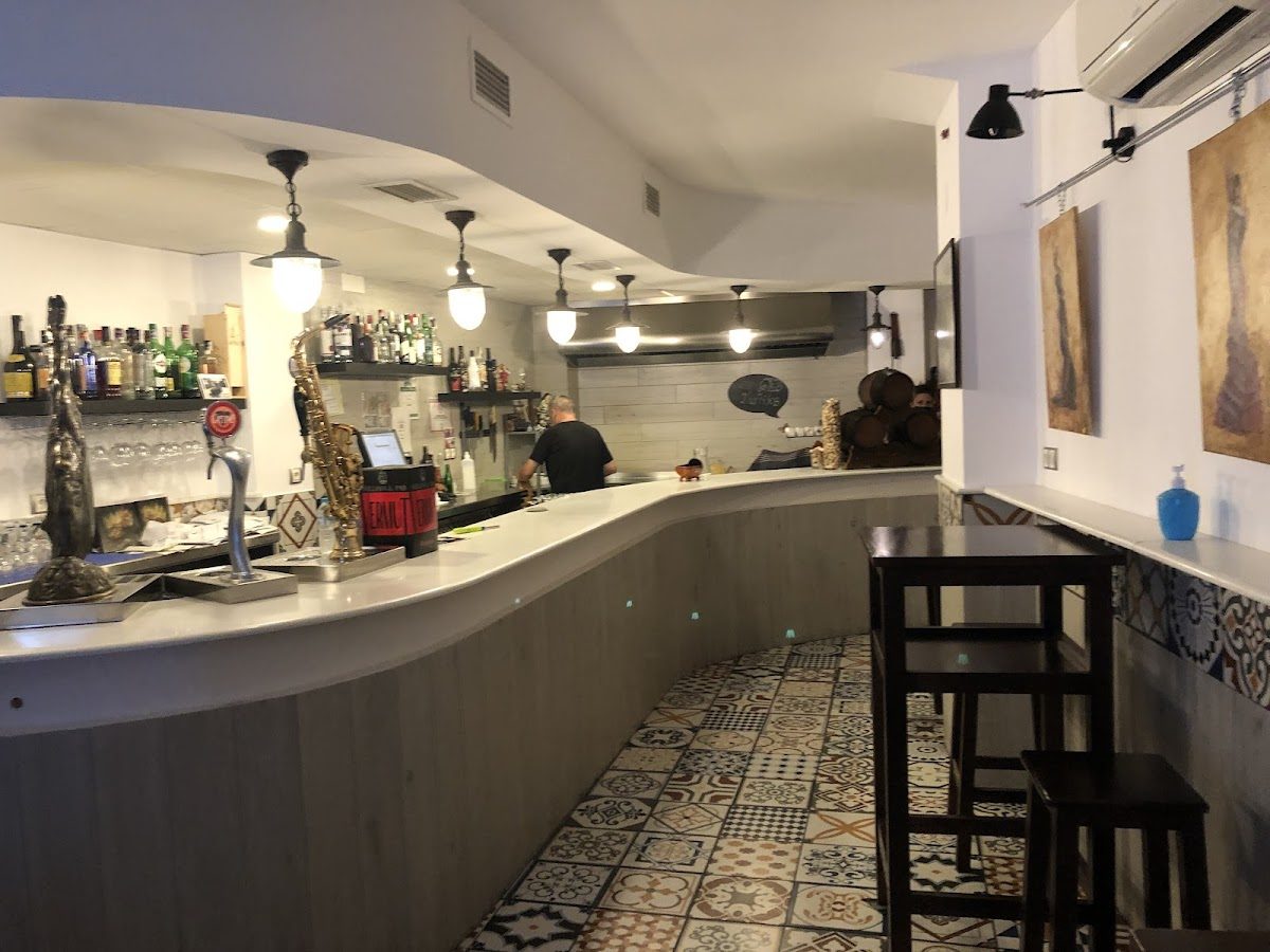 The interior of Los Barriles features a curved bar, decorative tiles, and a cozy atmosphere.