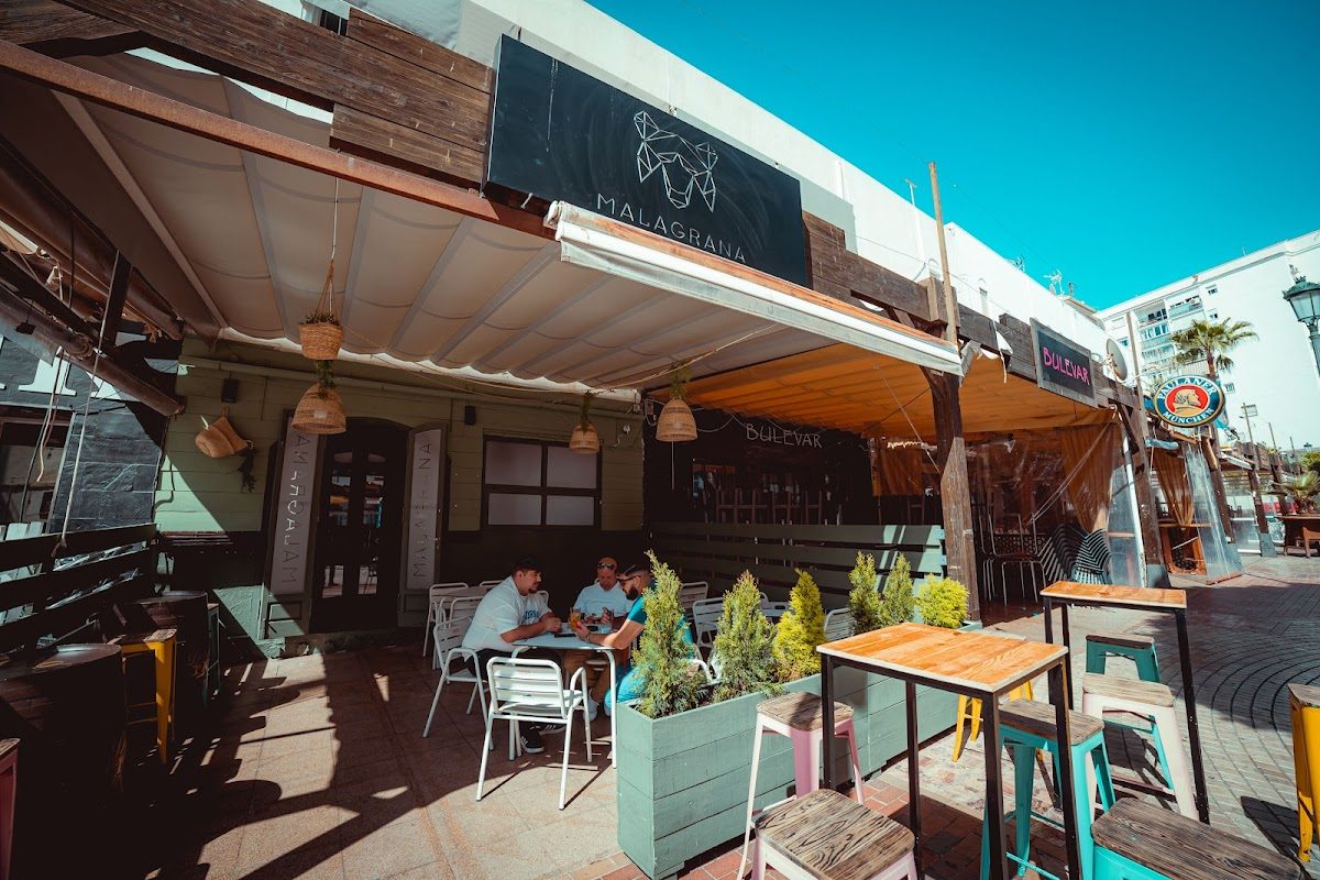Malagrana Nerja features a vibrant outdoor seating area with colorful tables and a welcoming entrance.