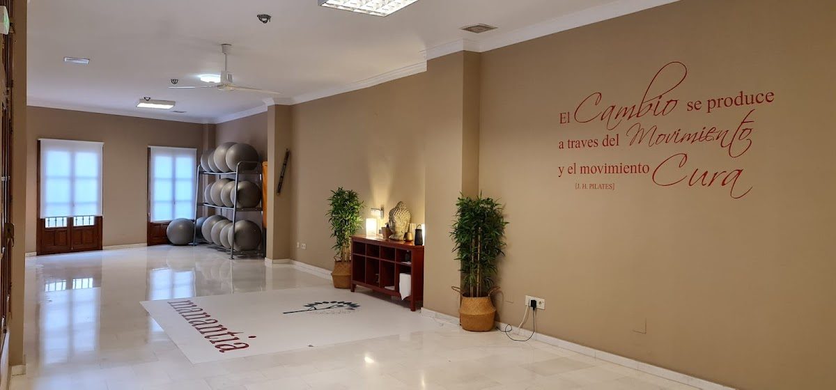 Interior of Manantia Internacional Wellness Center in Nerja, featuring a spacious hallway with plants and motivational wall art.