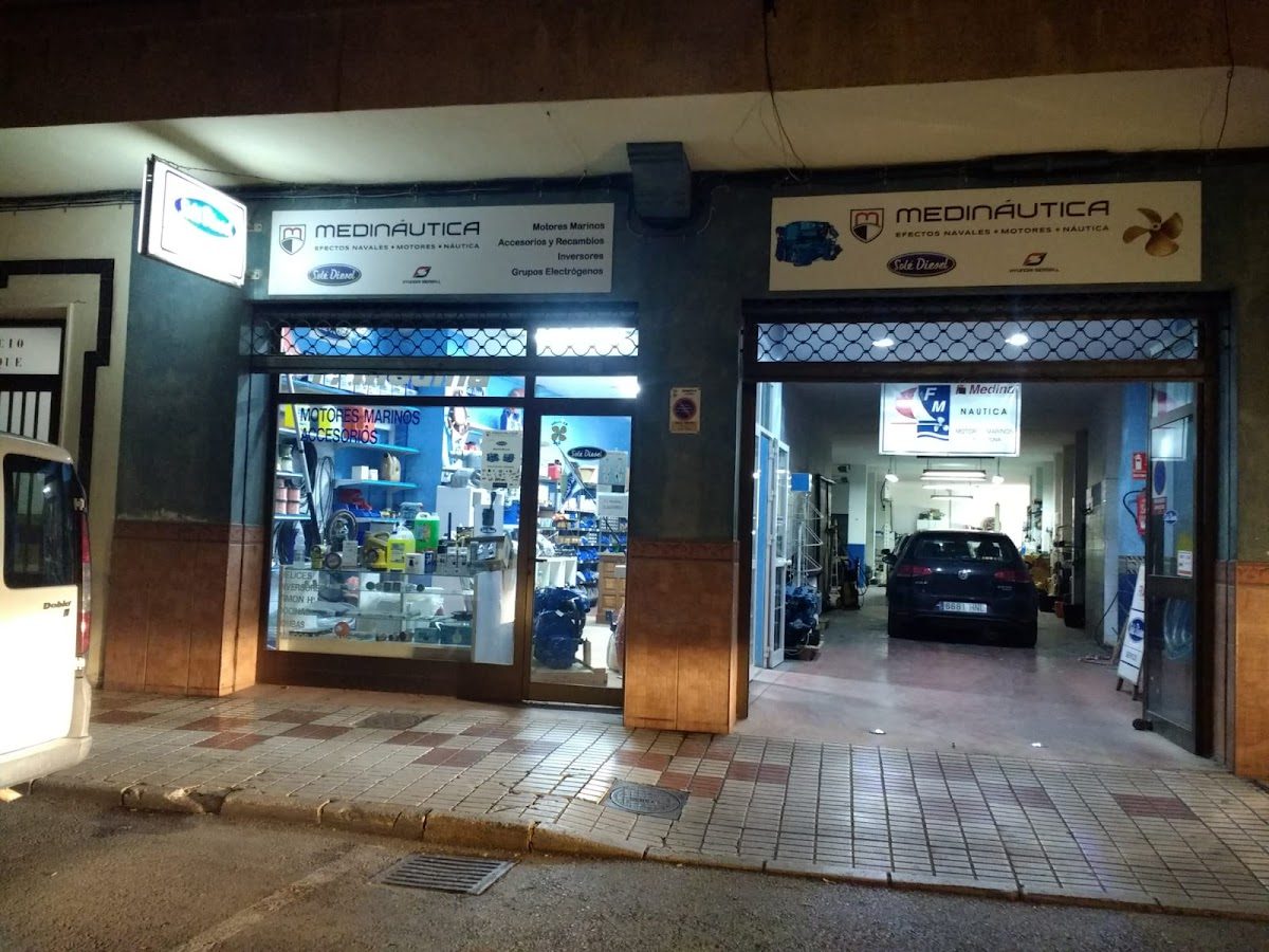 Medináutica storefront featuring marine parts, equipment, and a parked car outside.