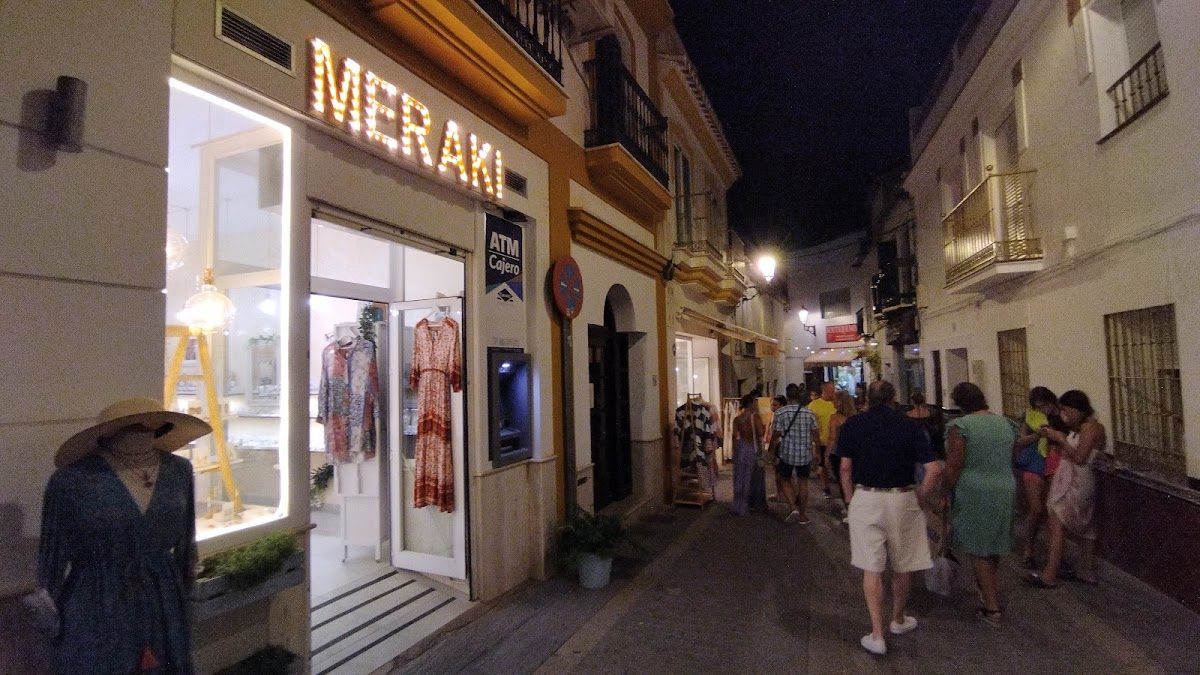 The MERAKI shop features stylish clothing and accessories, located on a lively street in Nerja.