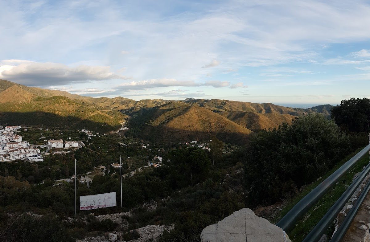 Scenic view of rolling hills and valleys near Mirador de Ojén, with a glimpse of the village below.