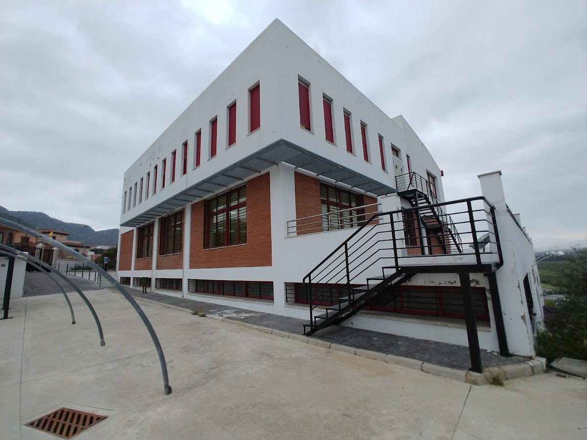 The Municipal School of Music "Carlos Álvarez" features a modern building with red accents and a staircase.