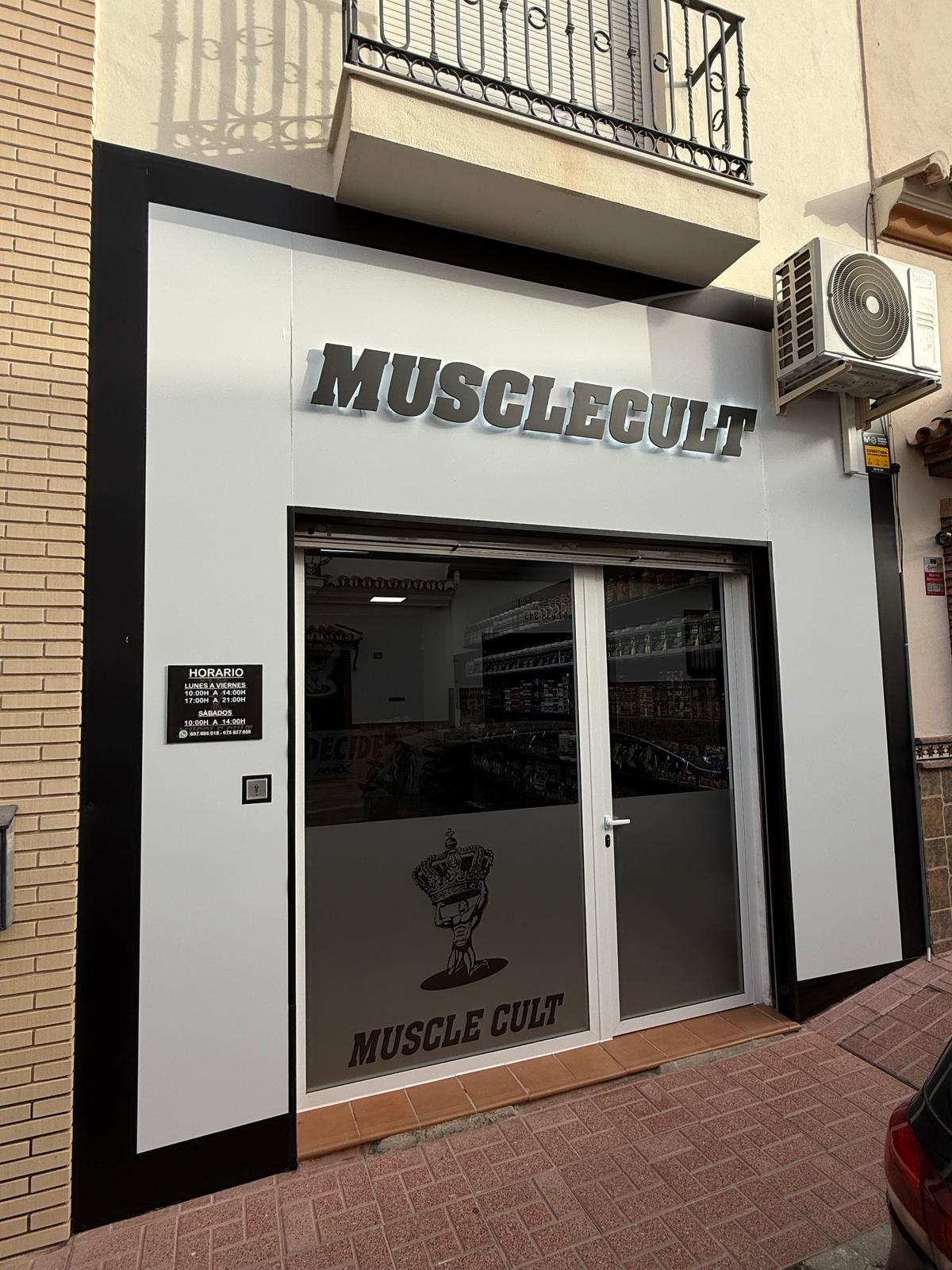 El exterior de MuscleCult presenta una fachada moderna con grandes letreros y ventanas de cristal.