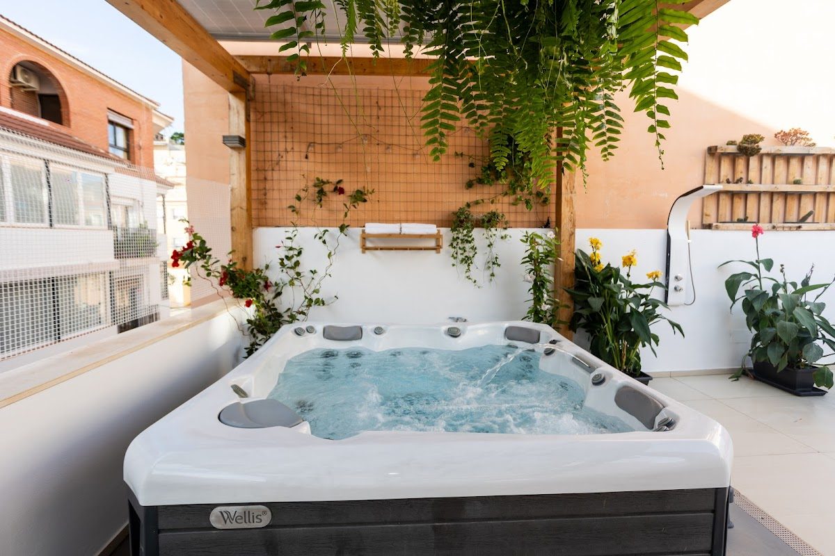 Un relajante jacuzzi al aire libre rodeado de plantas en Naim Guest House en La Cala del Moral.