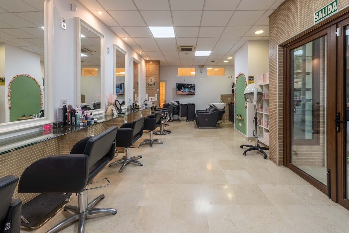 Interior de NH Belleza con sillones de peluquería, espejos y zona de recepción.