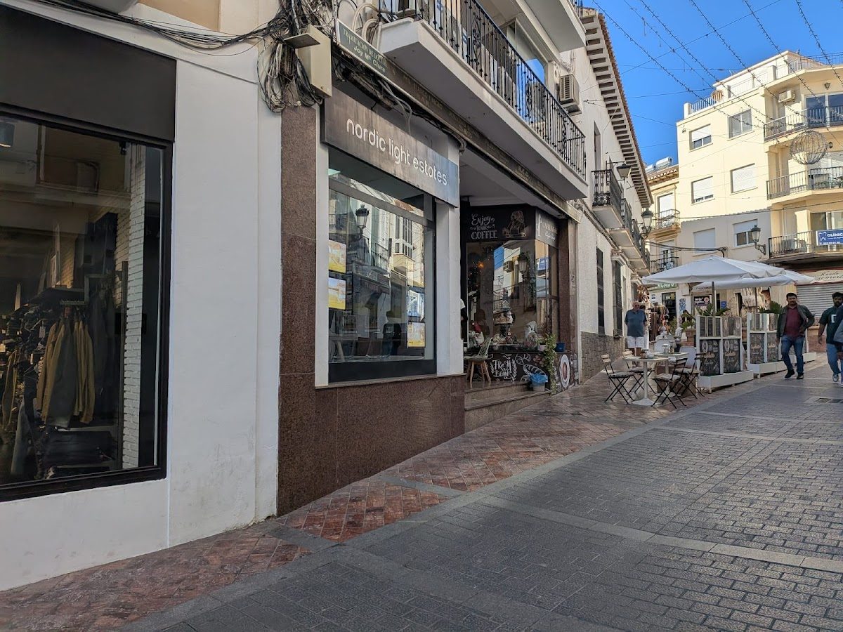 Nordic Light Estates features a modern storefront with large windows and outdoor seating nearby.
