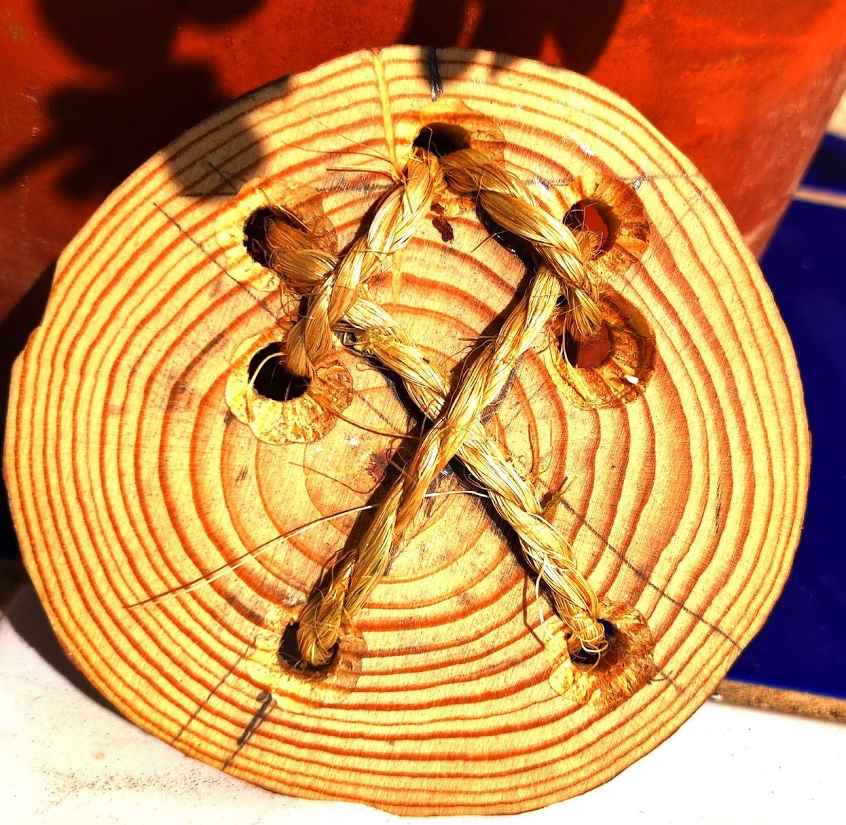 A handcrafted wooden disc with braided twine and circular patterns, displayed at NORROX in Torrox.