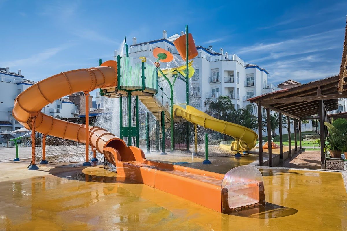 The image shows colorful water slides and a splash area at Occidental Torremolinos Playa hotel.
