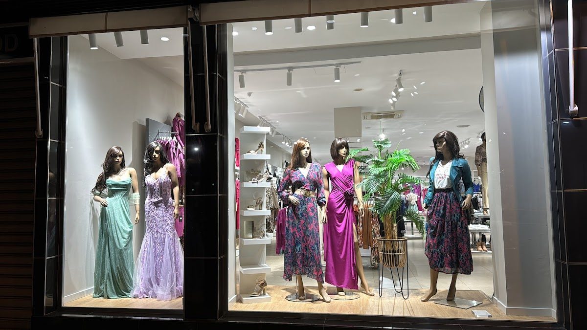 The window display of ODD Fashion features mannequins in elegant dresses and stylish outfits.
