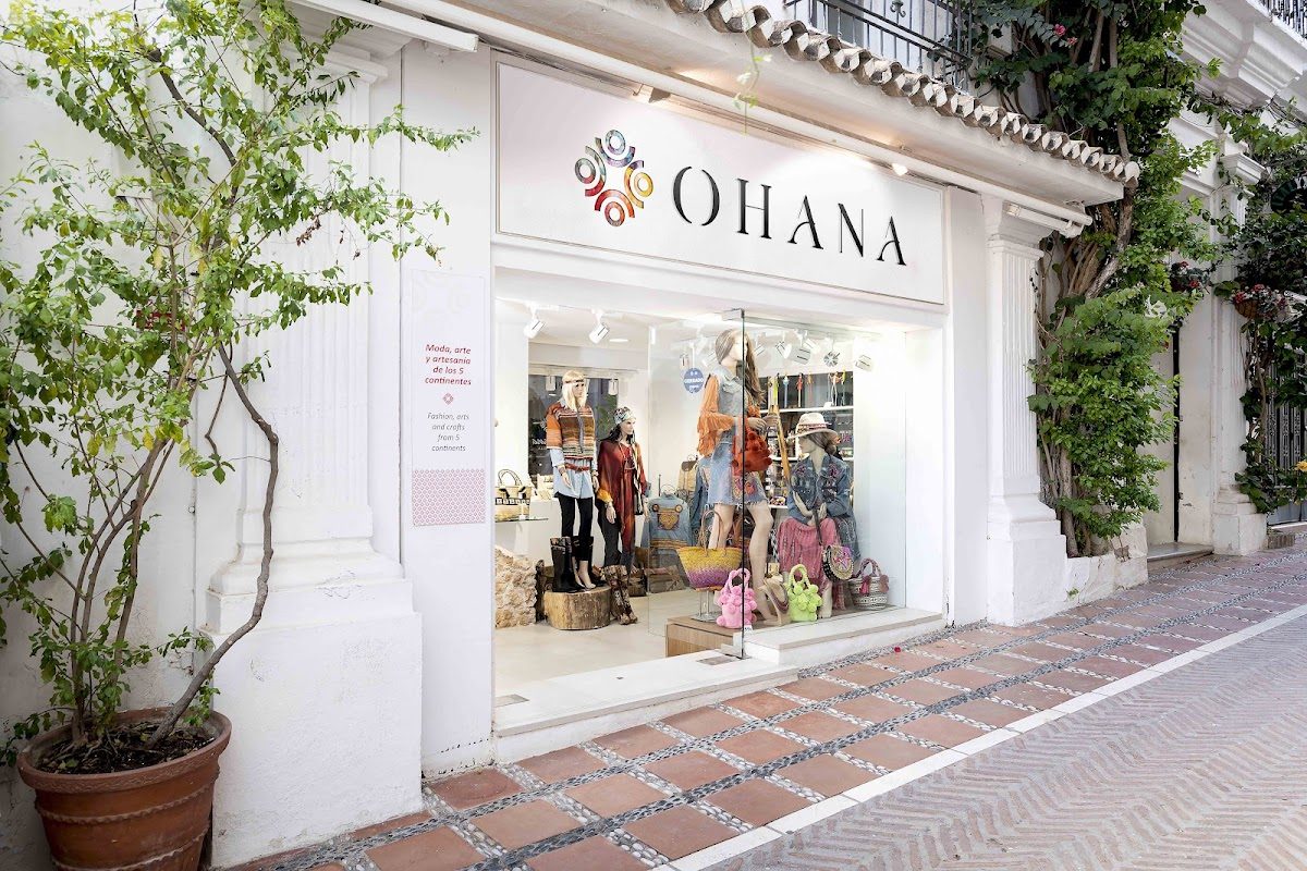 La tienda Ohana presenta un exterior elegante con coloridos escaparates y prendas de vestir expuestas en el escaparate.