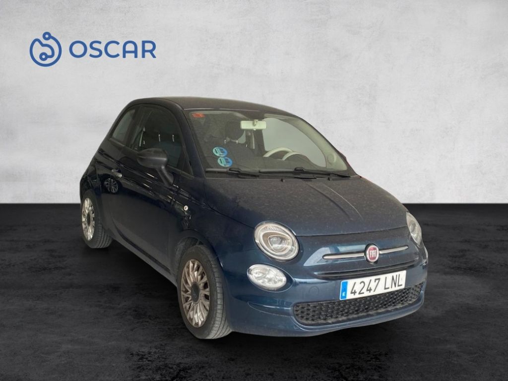 A blue Fiat 500 parked with the Oscar logo visible in the background.