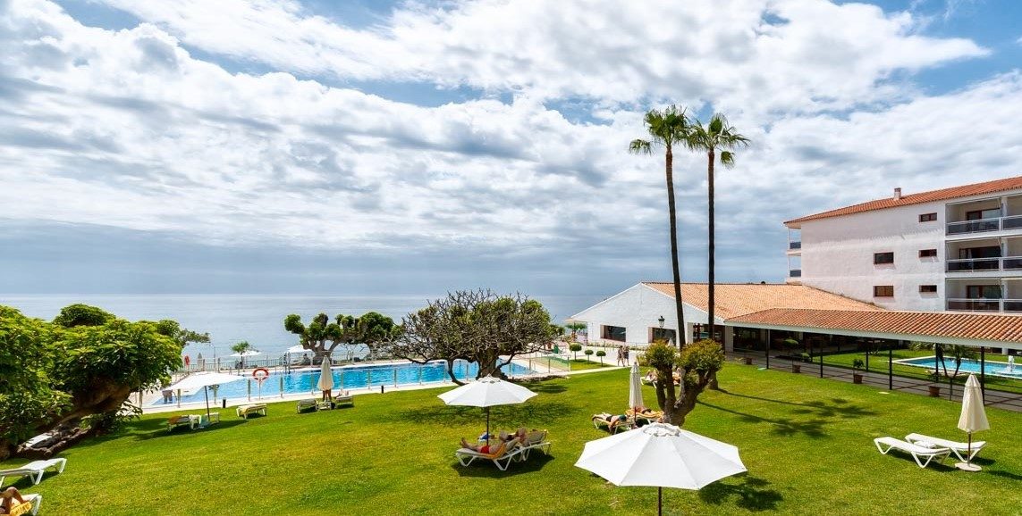 The Parador de Nerja features a spacious outdoor area with a pool, palm trees, and views of the sea.