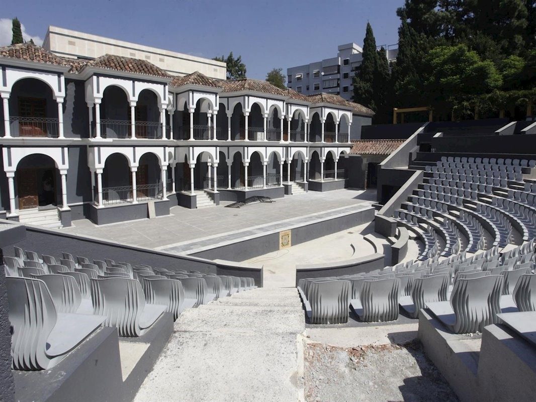La imagen muestra un anfiteatro con gradas escalonadas y un fondo de arcos en el Parque de la Constitución.