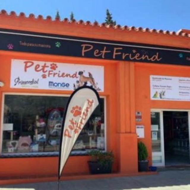Fachada de color naranja brillante de Pet Friend, con artículos para mascotas y un cartel de bienvenida.