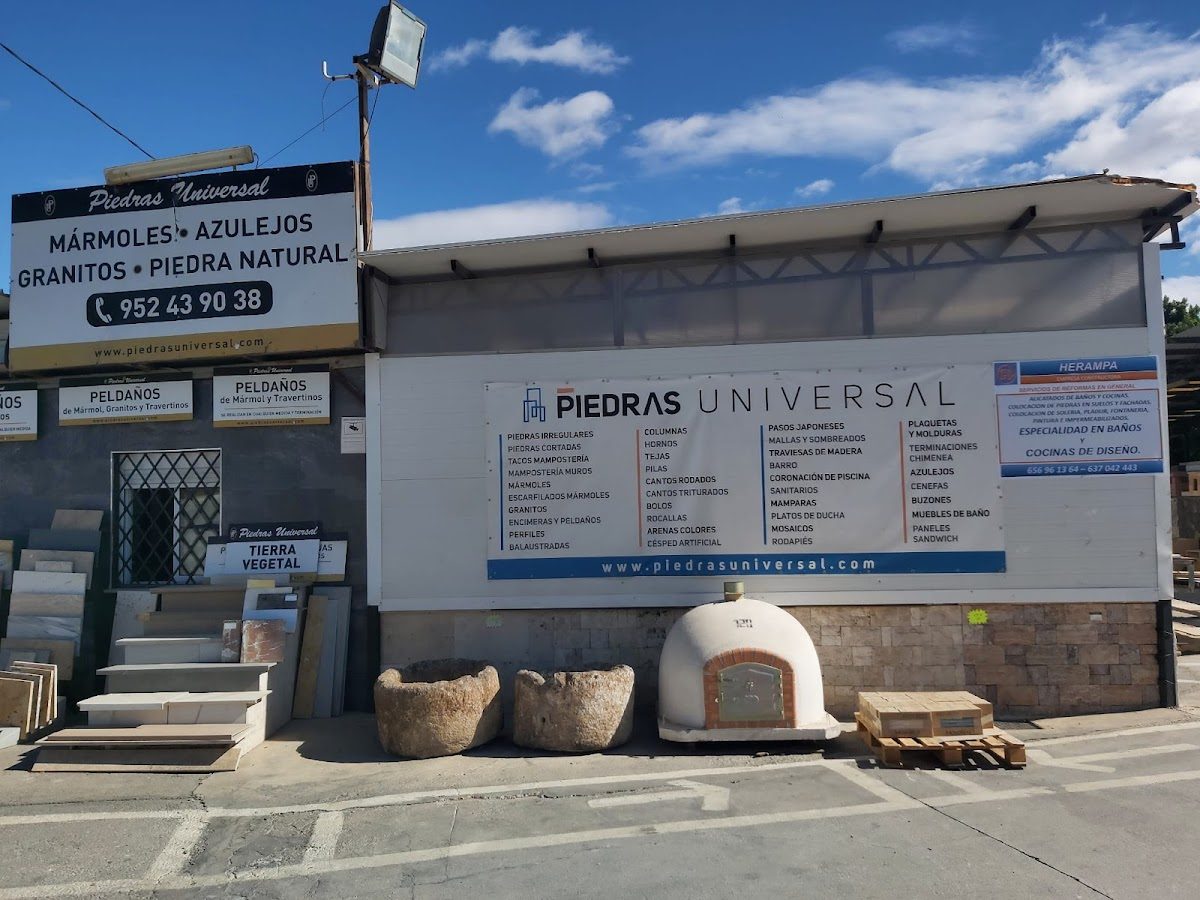 Piedras Universal storefront with signage displaying various stone products and a stone oven.