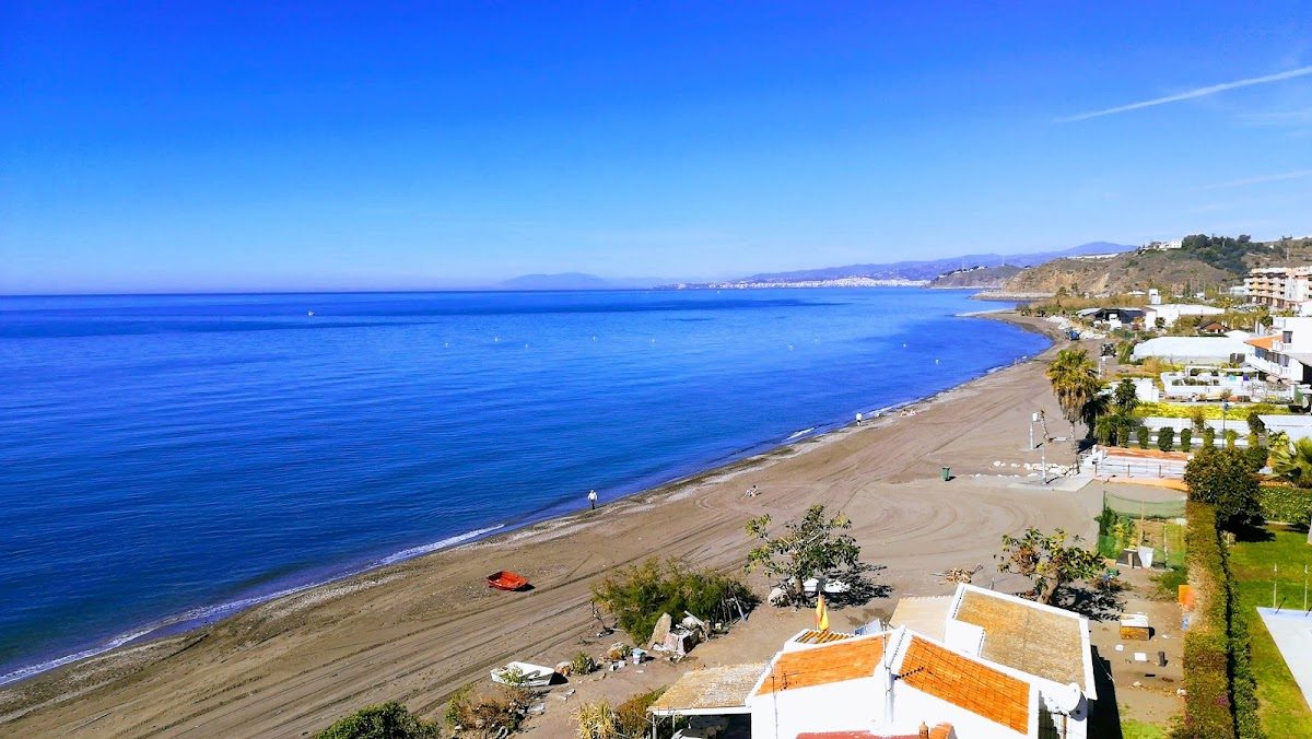 Scenic view of Playa de El Morche beach with calm waters and sandy shoreline.