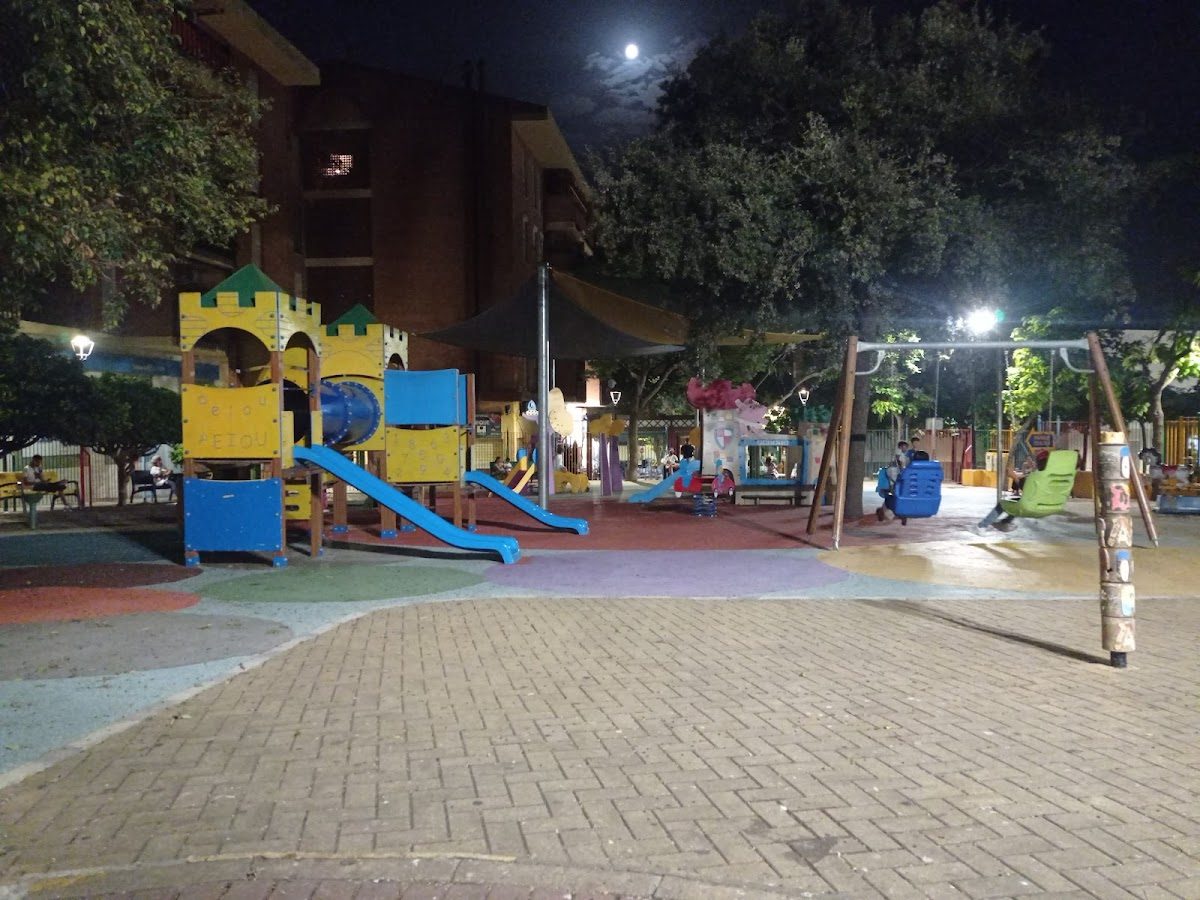 Juegos infantiles coloridos con toboganes y columpios bajo la luz de la luna en el Parque de Juegos Pocoyo en Benalmádena.
