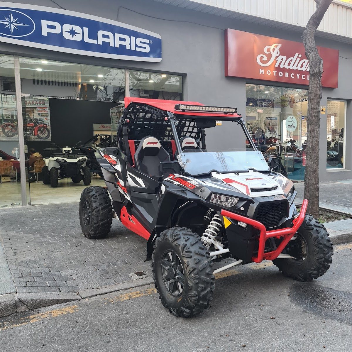 Un vehículo todoterreno rojo y negro está aparcado frente a la tienda POLARIS SIEBLA en Marbella.