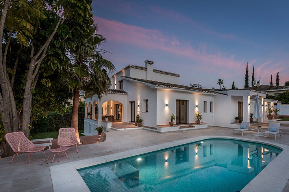 El edificio ProMas cuenta con una villa moderna con piscina, rodeada de palmeras y con asientos al aire libre.
