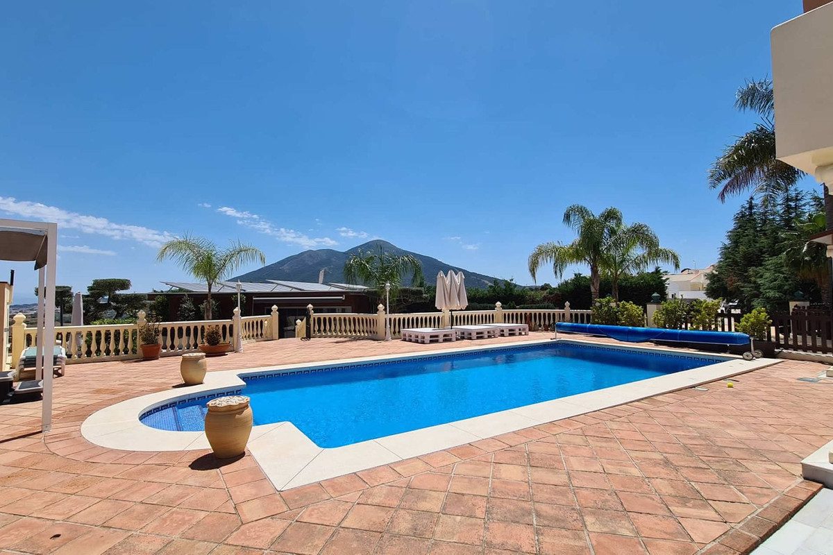 Property Overseas Group ofrece una amplia zona al aire libre con piscina, rodeada de palmeras y con vistas a la montaña.