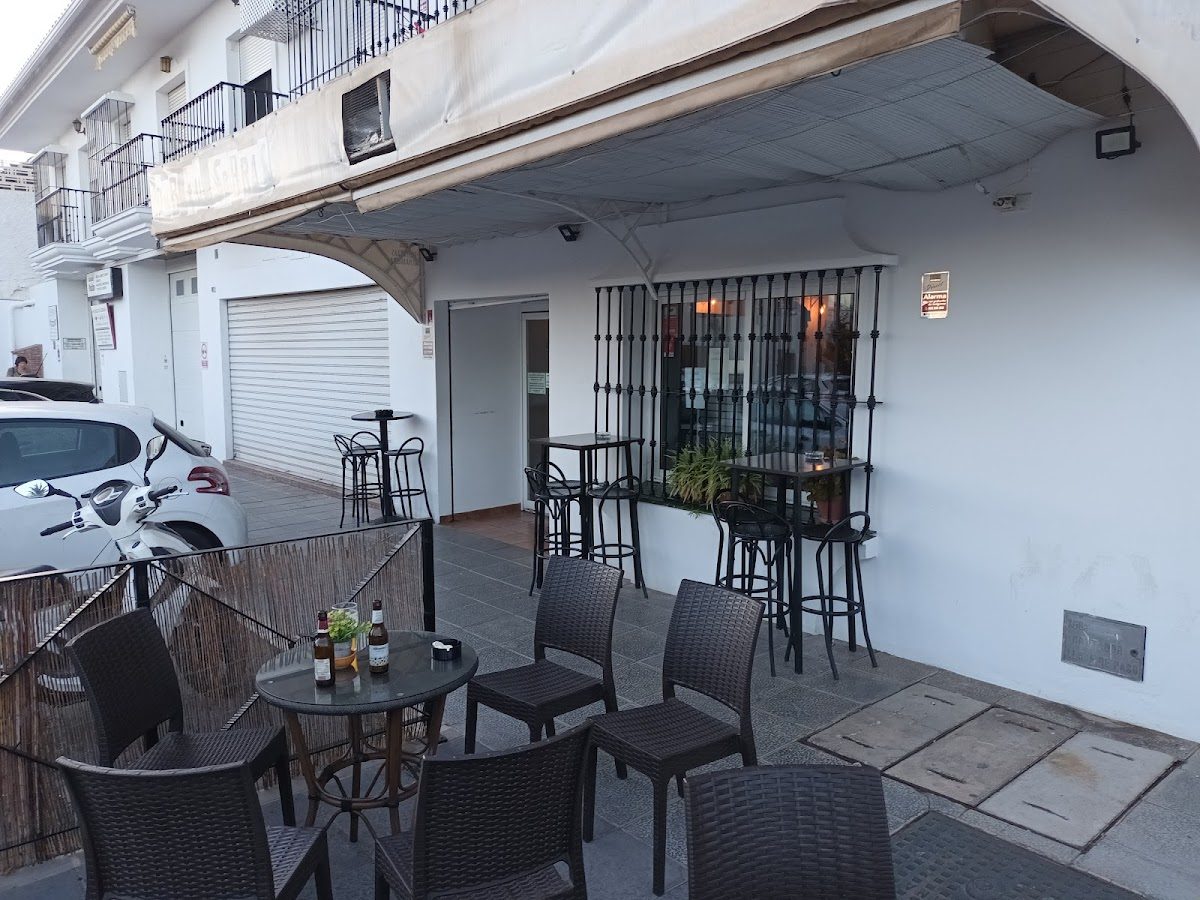 Terraza con mesas y sillas frente al pub "Tú Sabrás" en la Av. de Méjico, Mijas.