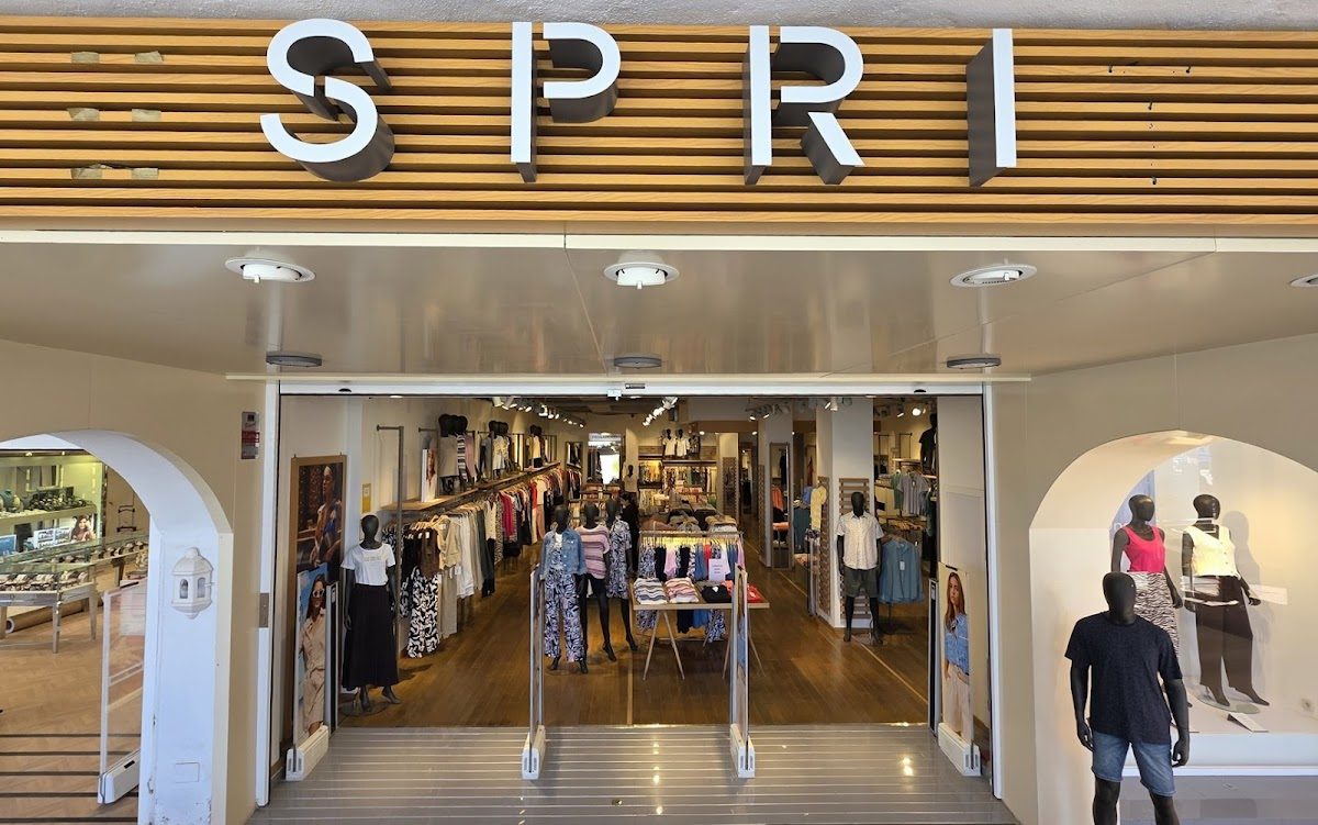 La entrada de la tienda SPRI en el centro comercial Puerto Marina, donde se pueden ver exhibiciones de ropa y maniquíes.