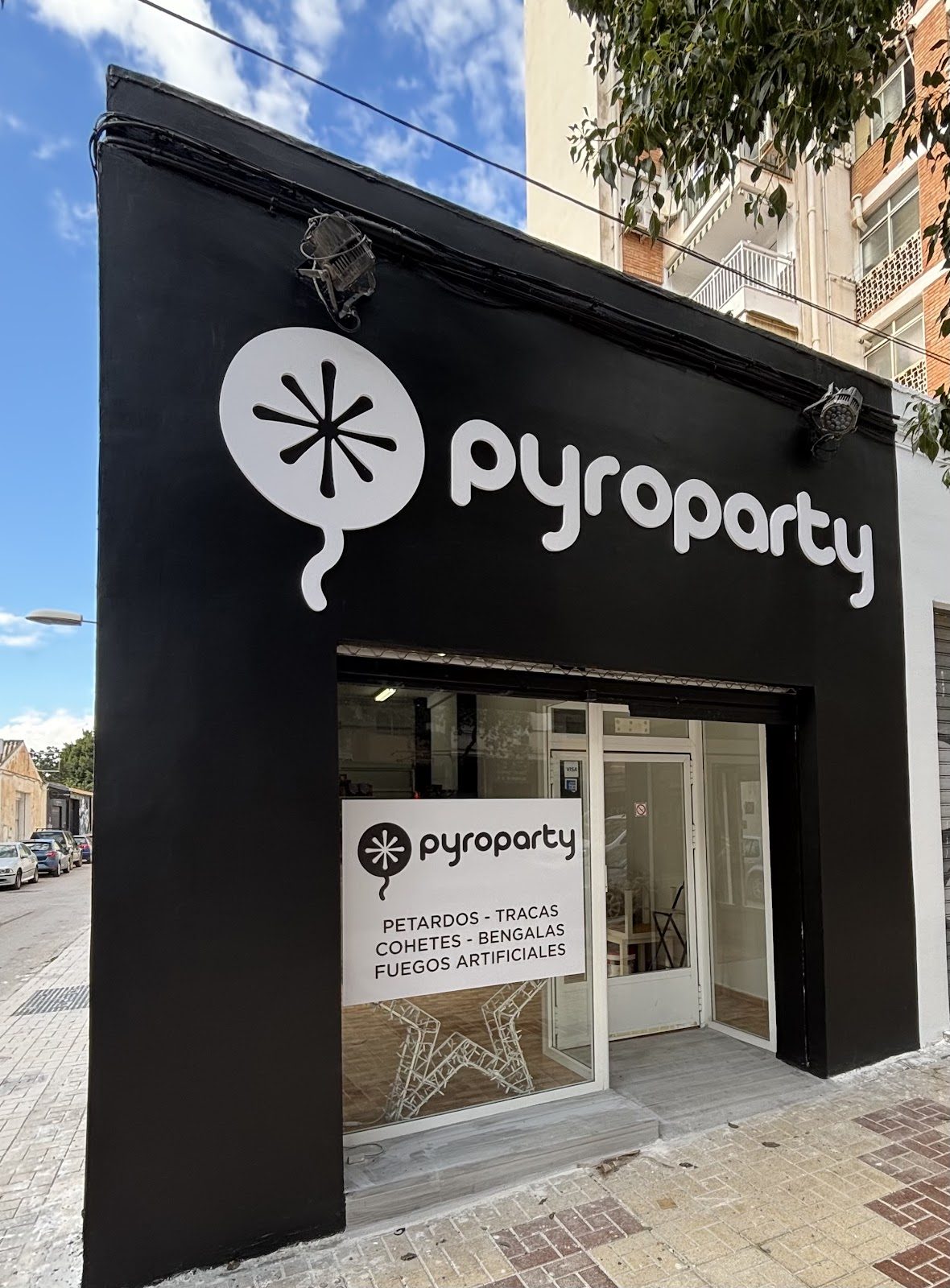 Exterior view of PyroParty Tienda de Pirotecnia, featuring a black facade and large white signage.