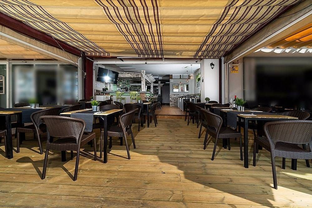 RAW Lounge features a spacious outdoor dining area with wooden flooring and wicker tables and chairs.