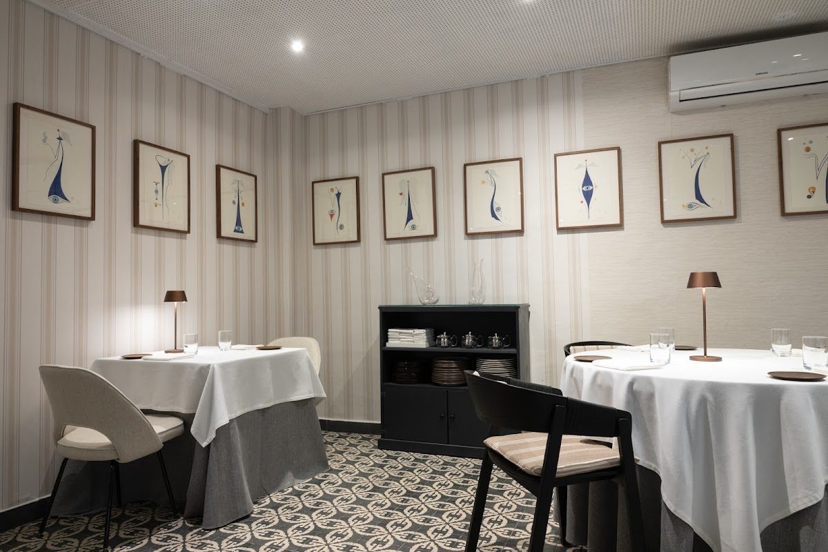 Elegante comedor en el Restaurante BACK con decoración minimalista y obras de arte en las paredes.