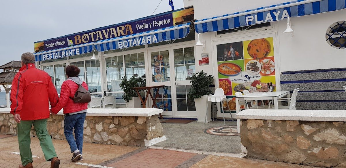 El restaurante Botavara presenta un exterior luminoso con toldos azules y blancos y mesas al aire libre.