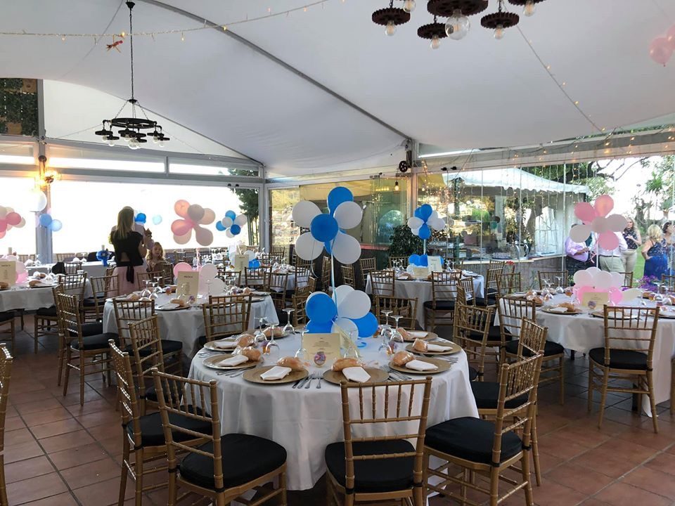 Restaurante El Fogón de Flore features elegantly set tables with blue and pink decorations in a spacious dining area.