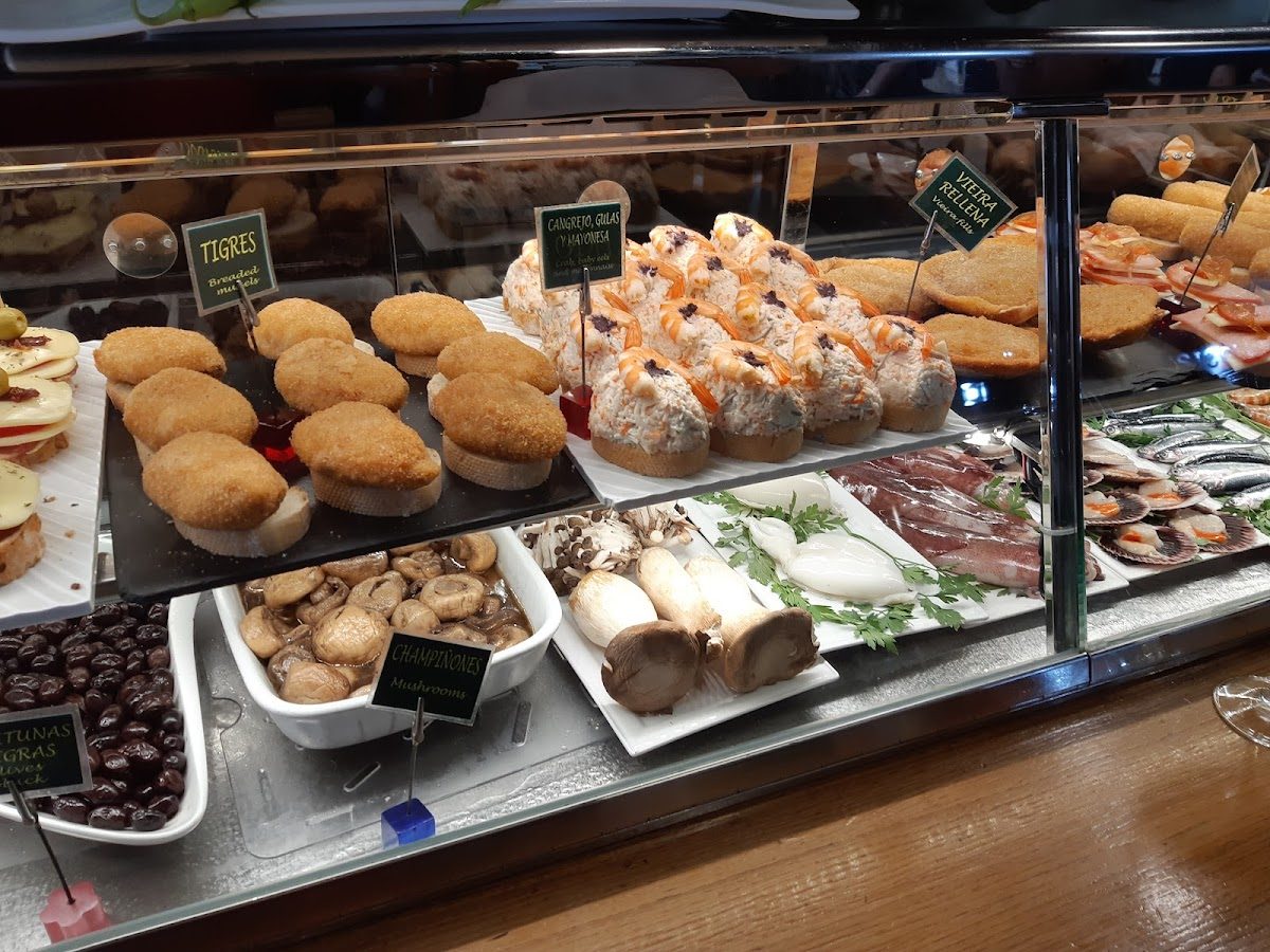 A display of various tapas including seafood, stuffed mushrooms, and croquettes at Restaurante Gau-txori.