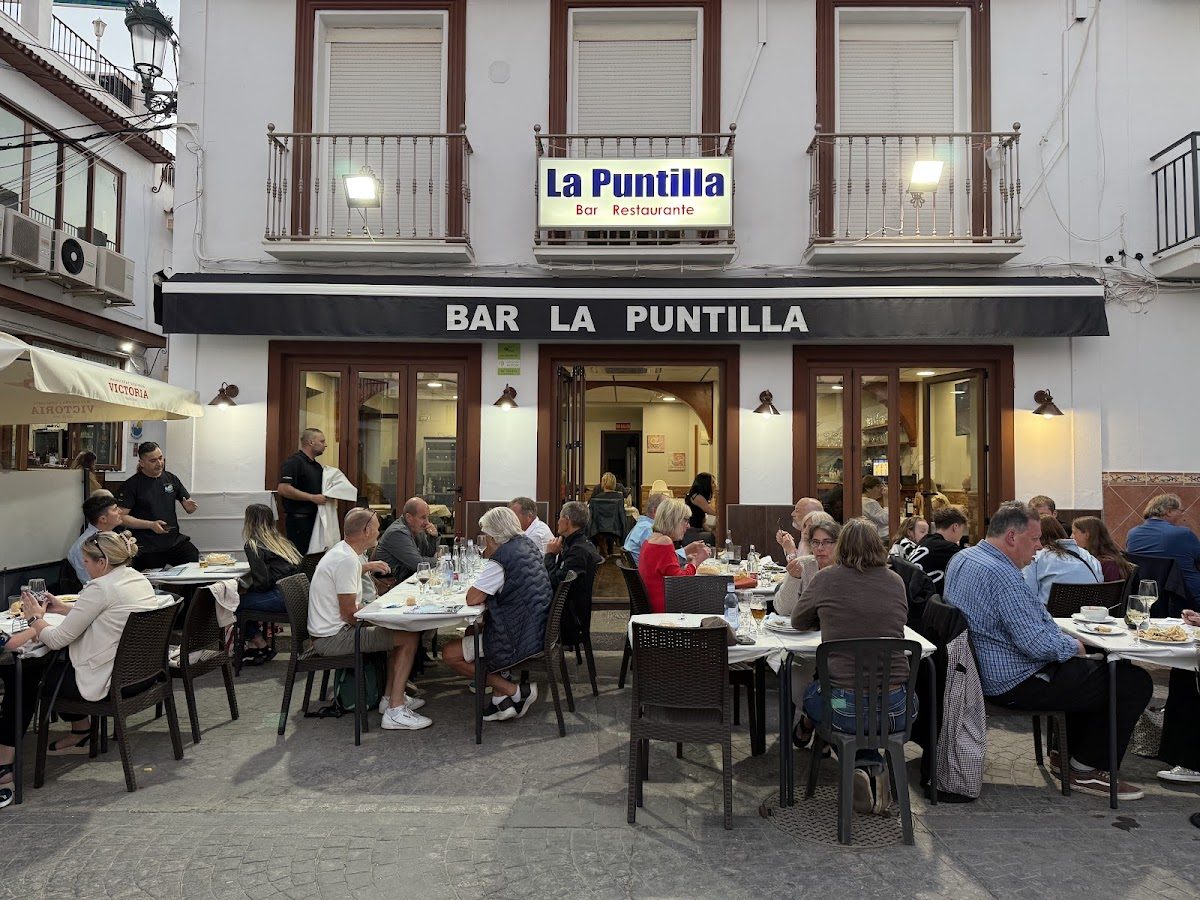 Outdoor dining area of Restaurante La Puntilla, with patrons enjoying meals at tables.