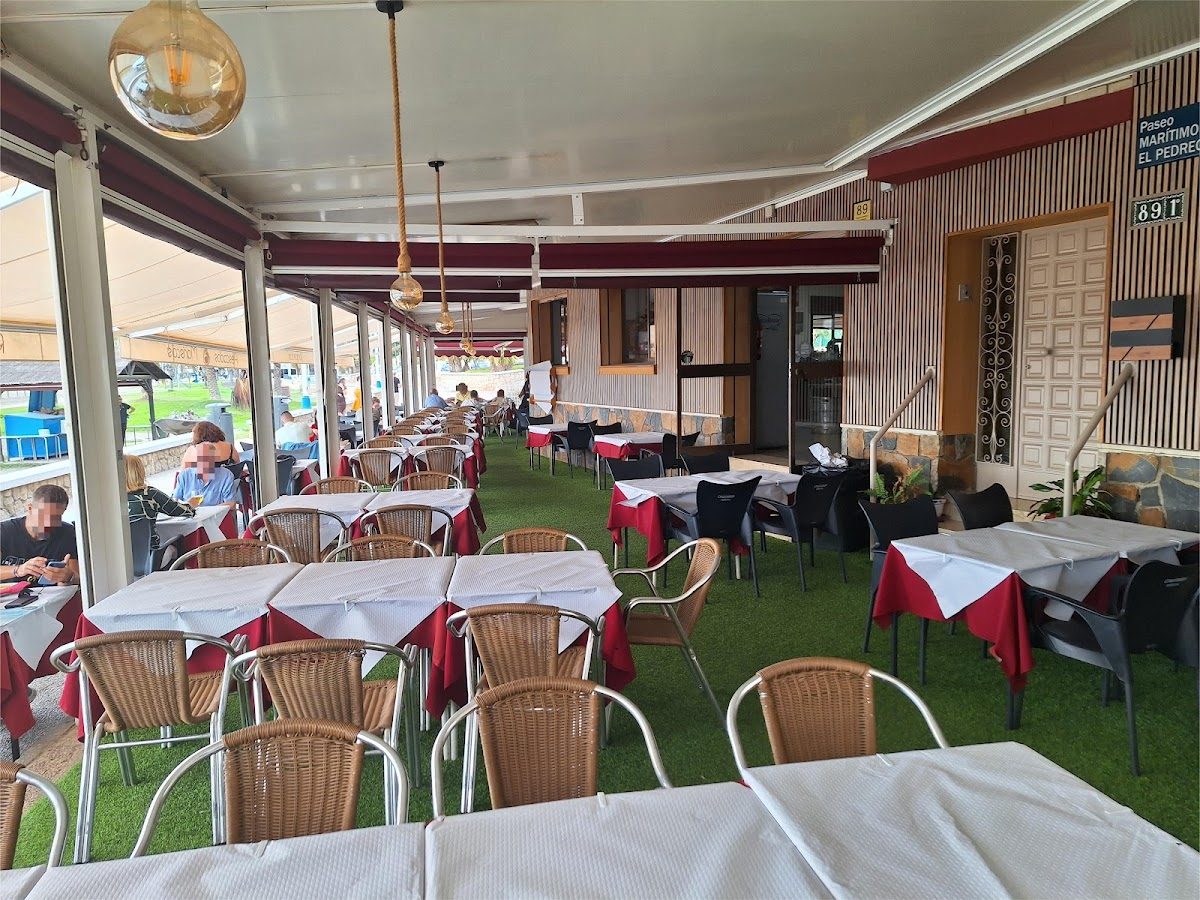 Restaurante Rompeolas features a spacious outdoor dining area with tables set for guests.