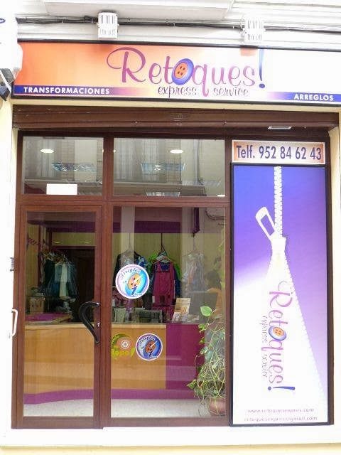 The storefront of Retoques features colorful signage and displays clothing alterations services.