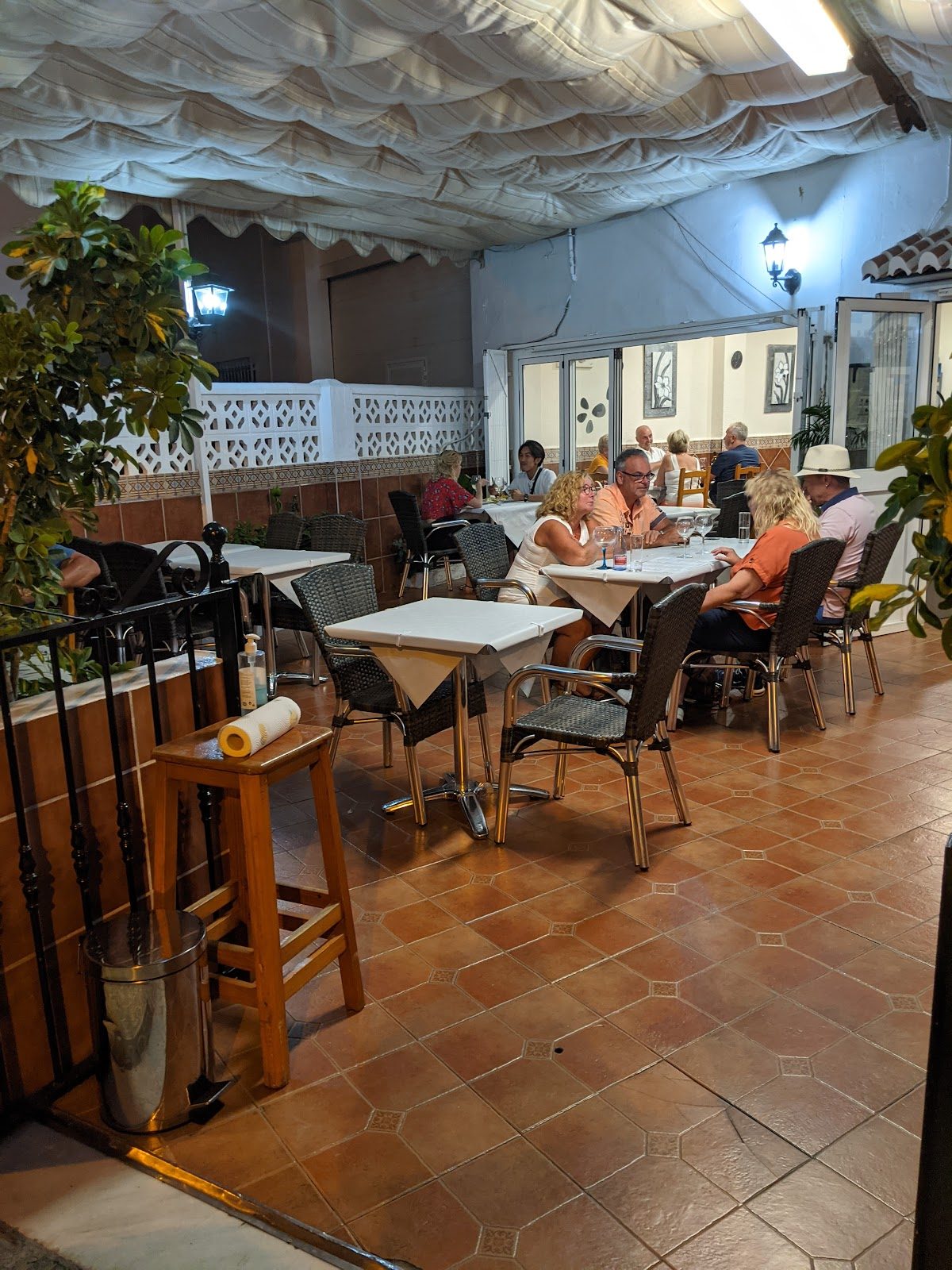Outdoor dining area of Rincon del Sabor with tables, chairs, and patrons enjoying their meals.