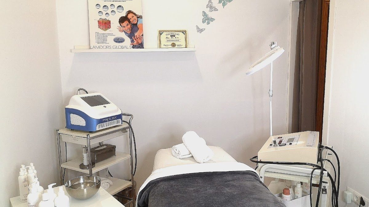 A treatment room featuring a bed, beauty equipment, and skincare products at Salón Alicia Alba Estética y Peluquería.
